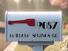 a white mailbox with a red handle and the words willow springs rd on it