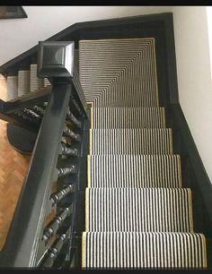 the stairs are lined with black and white striped rugs