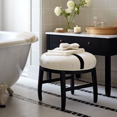 a white bath tub sitting next to a black and white counter top in a bathroom