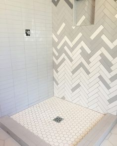 a white tiled shower with hexagonal tiles