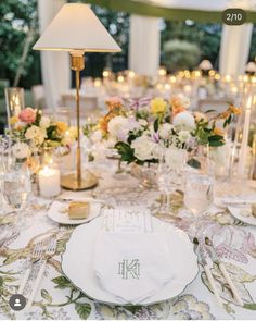 the table is set with flowers, candles and place settings for an elegant dinner party