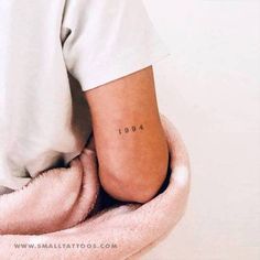 a person with a small tattoo on their left foot, sitting in a bathrobe