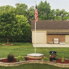 an american flag is in the middle of a flower bed