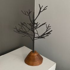 a wooden vase with branches in it on a white table