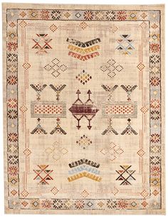 an antique rug with geometric designs on the front and back, in beige tones is shown