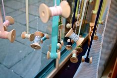 an assortment of wooden spools hanging from strings