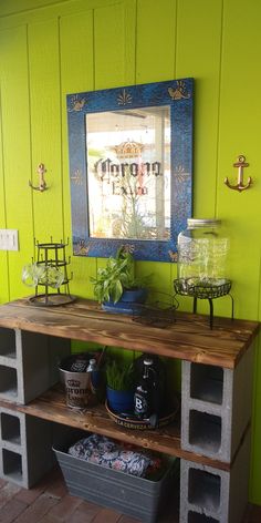 a wooden table sitting in front of a mirror on the wall next to a potted plant