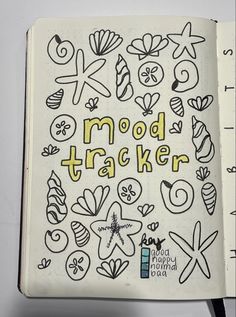 an open notebook with doodles on it that says mood trackerr written in yellow