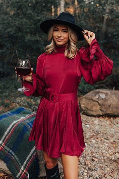 - Pop the cork and sip in style with this fabulous dress! - Lightweight material with a satin finish and a built-in lining - A smocked mock neckline - Back zip closure - Long, loose sleeves with smocked ruffle cuffs - A waistline with a detachable buckle closure belt - A flowy yet flattering silhouette that ends in a ruffled hemline Western Formals Women, High Neck Mini Dress For Cocktail In Fall, High Neck Mini Dress For Fall Cocktail, Fall High Neck Cocktail Mini Dress, Fall Mini Dress In Satin For Brunch, Fall Satin Mini Dress For Brunch, Chic Burgundy Satin Dress, Burgundy Mini Dress For Fall Cocktail, Loose Sleeves