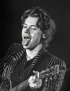 a man holding a guitar and making a funny face