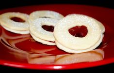 small cookies with jelly filling on a red plate