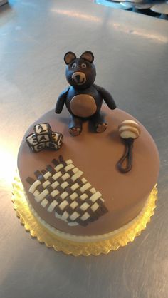 a chocolate cake decorated with a teddy bear and other decorative items on a silver surface