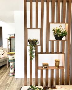 a living room filled with lots of furniture next to a wall mounted planter and bookshelf