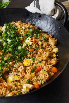 a pan filled with rice and vegetables on top of a table