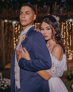 a man in a blue suit and woman in a white dress standing next to each other