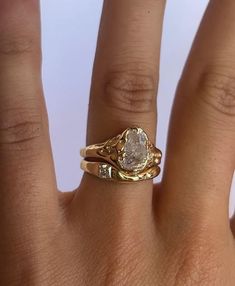 a woman's hand with a yellow gold ring on it and a diamond in the middle