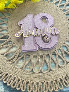 the number twenty nine is displayed on a doily with yellow flowers in the background