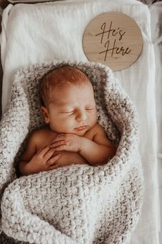 a baby is sleeping in a crocheted blanket with his hands on his chest