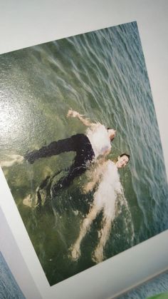 a man swimming in the water with his feet up