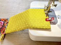 a close up of a sewing machine with a yellow tie on it's side