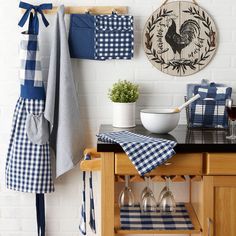 a kitchen counter with wine glasses and napkins hanging on the wall next to it