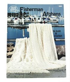 there is a white knitted blanket on the cover of this knitting pattern for fisherman afghans