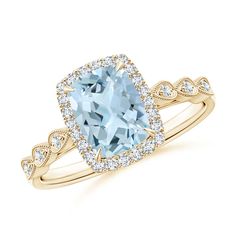 a ring with an aqua blue topazte surrounded by white and yellow gold diamonds