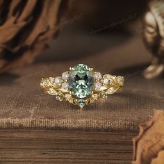 a green and white ring sitting on top of a wooden table next to a book