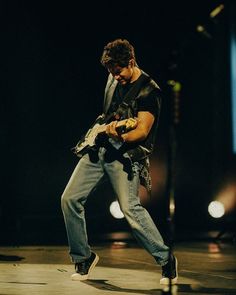 a man playing an electric guitar on stage