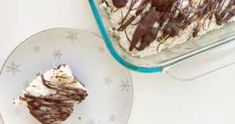 a piece of cake sitting on top of a plate next to a glass container filled with ice cream