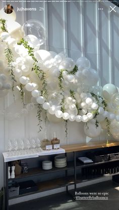 balloons and greenery are hanging from the ceiling