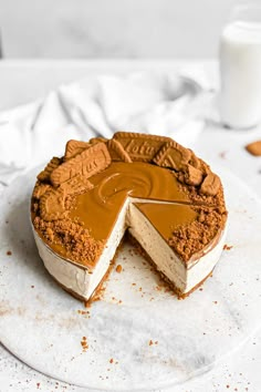 a cake that has been cut into pieces and is sitting on a white plate with a glass of milk in the background