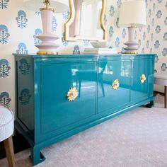 a blue dresser with two lamps on top