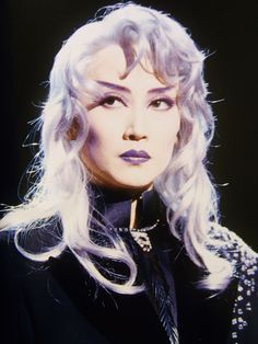 a woman with long white hair and purple lipstick