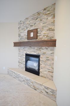 a stone fireplace with a wood mantle in the middle and tile on the back wall