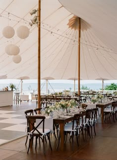 tables and chairs are set up under a large tent