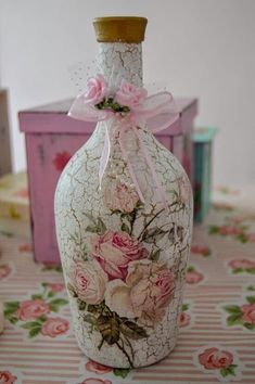 a vase with flowers painted on it sitting on a table next to a pink box