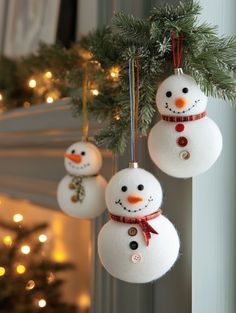 three snowman ornaments hanging from a christmas tree