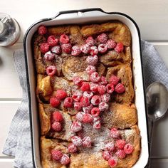 a casserole dish with raspberries and powdered sugar