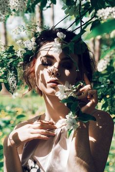 a woman with flowers in her hair is posing for the camera while wearing a flower crown