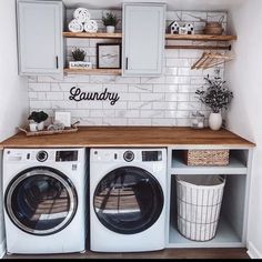 a washer and dryer in a small room with white tile on the walls