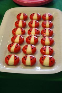 red and white cookies are arranged on a plate with green table cloths in the background