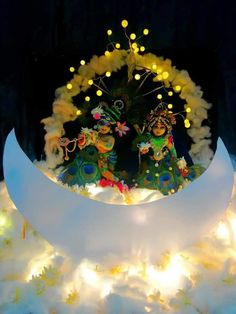 an elaborately decorated display in the shape of a crescent with lights around it and two figures on top