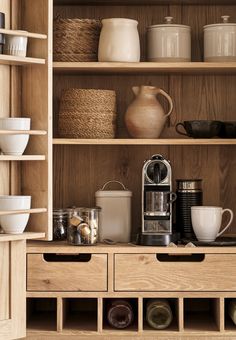 a wooden shelf filled with dishes and cups