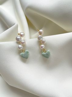 Woven freshwater pearls with a sage-white swirl heart charm. 
 - Pearl stud woven with 4 round freshwater pearls - 1/2" resin heart charm in a sage green and white swirl finish  - 18k gold plated brass 
 
 - Each order comes in a velvet pouch in our signature box, perfect for gifting Handmade Heart-shaped Pearl Jewelry, Green Pearl Drop Jewelry For Gifts, Green Pearl Drop Jewelry As Gift, Elegant Green Heart Beads Jewelry, Jade Pearl Drop Earrings As Gift, Elegant Green Jewelry With Heart Beads, Green Pearl Jewelry For Gifts, Green Pearl Earrings As Gift, Green Pearl Earrings For Gift