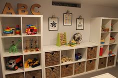 there are many toys on the shelves in this children's playroom with letters and pictures above them