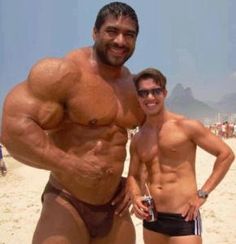 two men standing next to each other on the beach