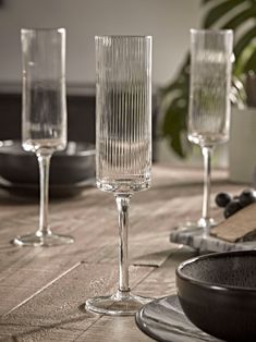 three wine glasses sitting on top of a wooden table