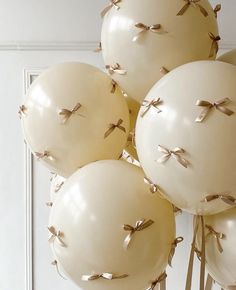 white balloons with bows on them in front of a door