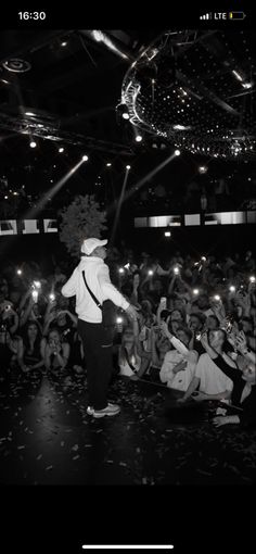 a man standing on top of a stage surrounded by people